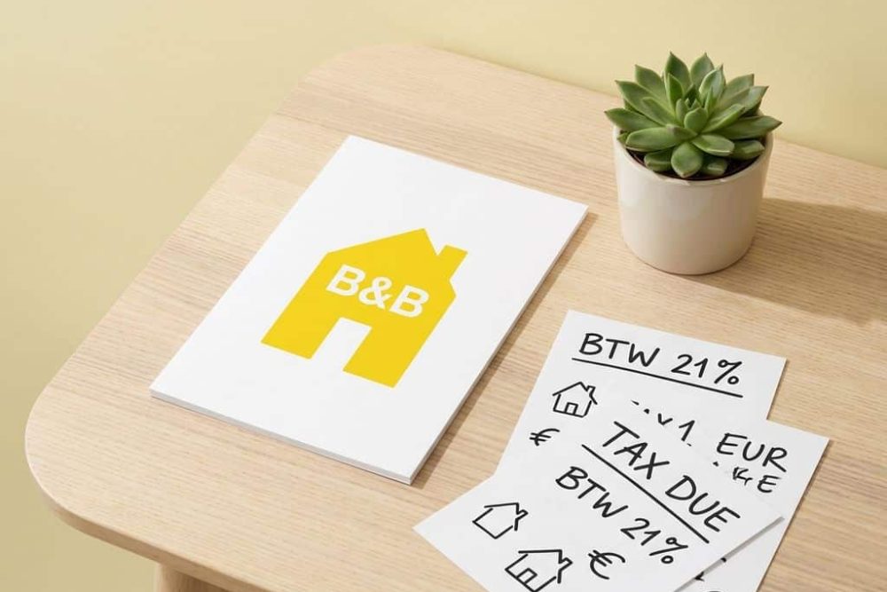 Geel B&B huisje icoon op bureau met BTW belastingformulieren en rekensheets voor professionele belastingadvies diensten